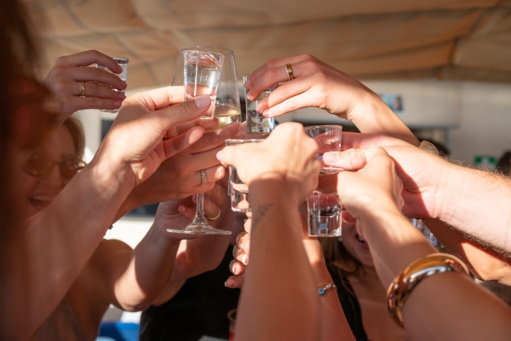 Brinde entre convidados numa festa pre-wedding em Lisboa, a bordo de uma experiência privada da Lisbon Sight Sailing no Rio Tejo.