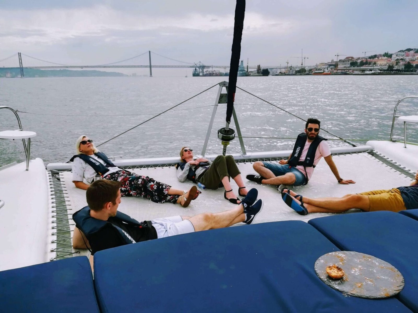 Personas relajándose tumbadas en la red del catamarán