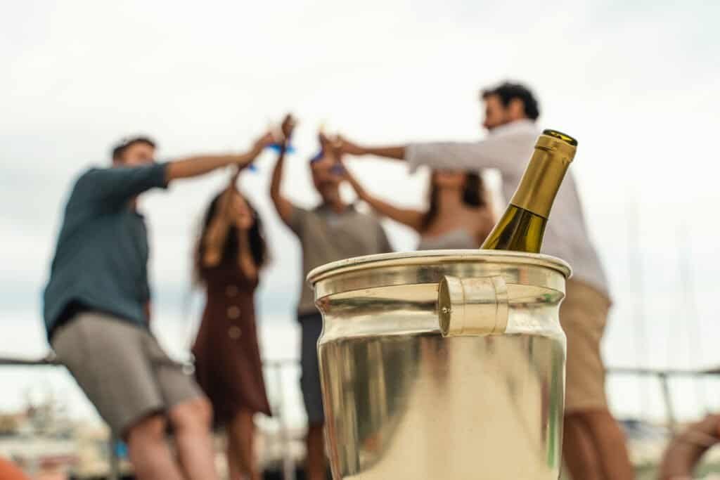 Amis trinquant avec du vin sur le pont du bateau