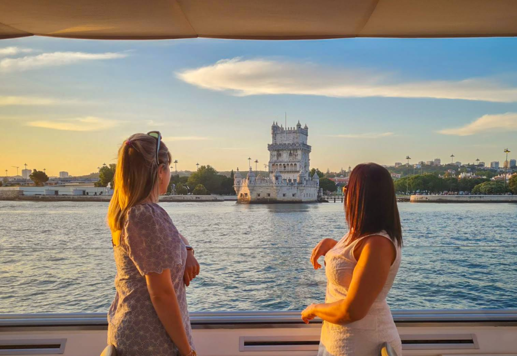 Pasajeros disfrutando de las privilegiadas vistas de la Torre de Belém directamente desde el barco.